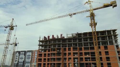 Grúas torre y estructura de armazón de edificios de apartamentos residenciales altos en el sitio de construcción Real