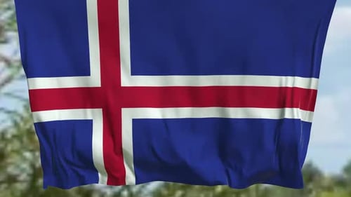 Iceland Flag Waving Against Blue Sky and Green Trees