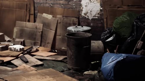 Cluttered Storage Filled with Boxes and Trash Bags in a Dim Space
