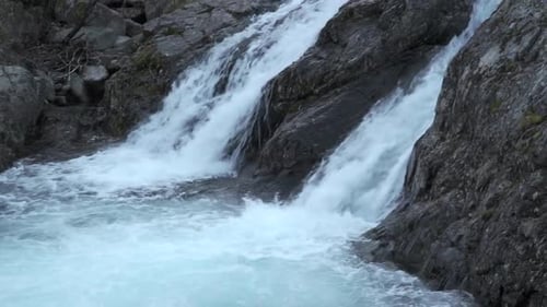 Blaues Wasser eines kleinen Wasserfalls im Herbstwald