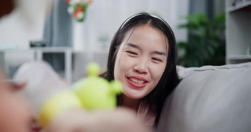 Smiling Young Woman on Sofa Relaxing Indoors