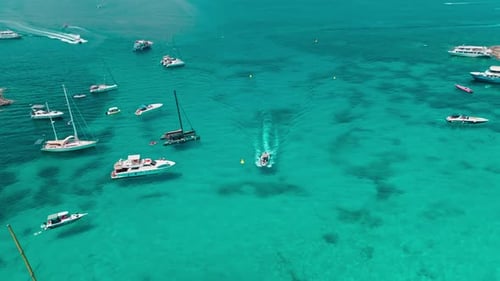 Aerial view of boats floating peacefully in crystal clear blue waters. Maritime beauty, summer adven
