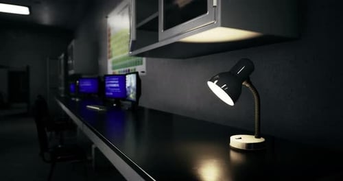 Workspace with Modern Desk Lamp and Computer Monitors in Dim Lighting