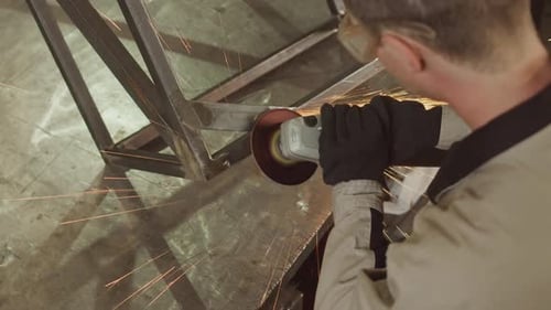Man Using Grinder Tool on Metal Construction
