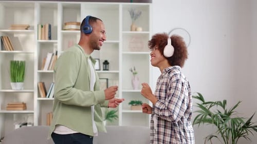 Happy Couple Dancing Together at Home with Headphones
