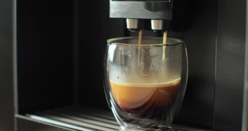 Espresso Pours into Glass from Coffee Machine