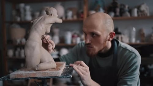 Focus on Sculptor Using Special Wooden Tool for Molding Working on His Unfinished Limestone Statue