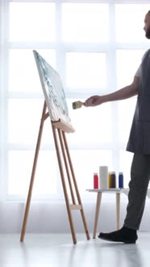 Artist Painting on Canvas in Studio with Brush