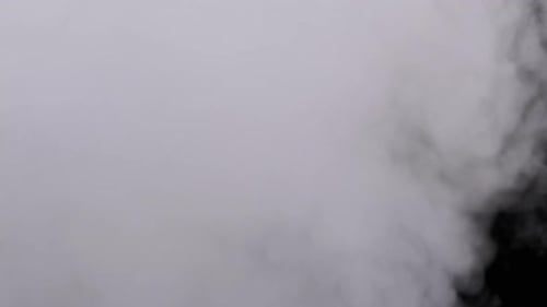 Real Explosion Vapor or Smoke Clouds Rise Up on Black Background in Slow Motion
