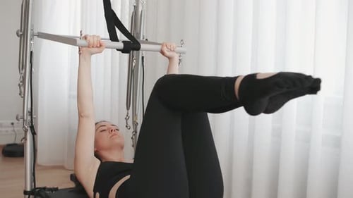 Woman Exercising on Pilates Machine in Studio
