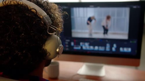 Selective Focus of Videographer in Headphones Watching on the Computer Screen Video Post Production