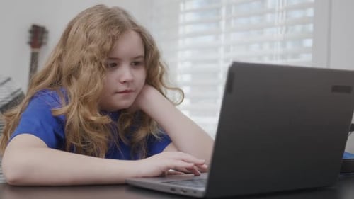 Child Typing on Laptop Keyboard Child Focused on Laptop Screen Child Learning Online Lessons School