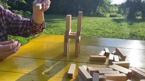 Woman Builds a Tower with Wooden Blocks As an Analogy of Balance Life