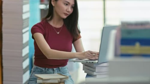Girl Student Uses Laptop in the School Library