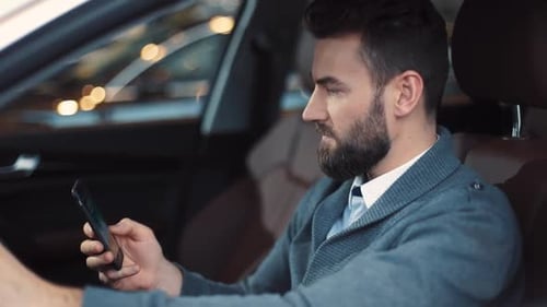 Man in Car Uses Mobile Phone