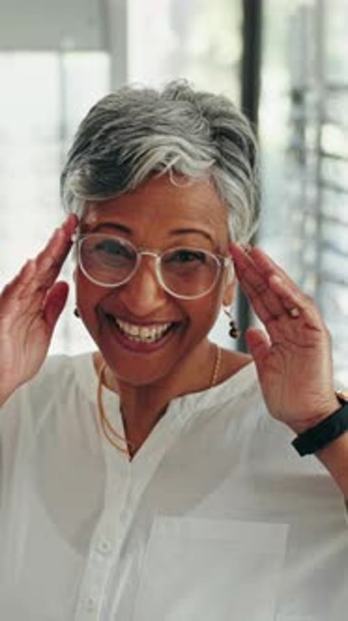 Smiling Woman Tries on Glasses at Home