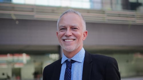 Smiling Man in Suit Outside Office Building