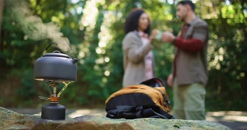Travel, stove and kettle with couple in nature for brewing coffee, trekking rest stop and woods