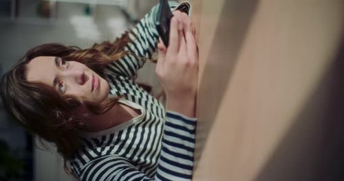 Woman Using Mobile Phone Indoors in Daylight