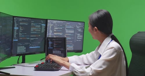 Asian Woman Developer Working With Tablet While Write Code With Computer In Green Screen Studio