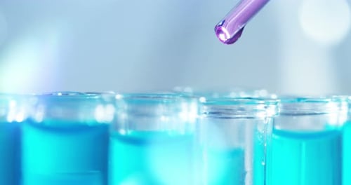 Purple Fluid Dripping into Test Tubes in Lab