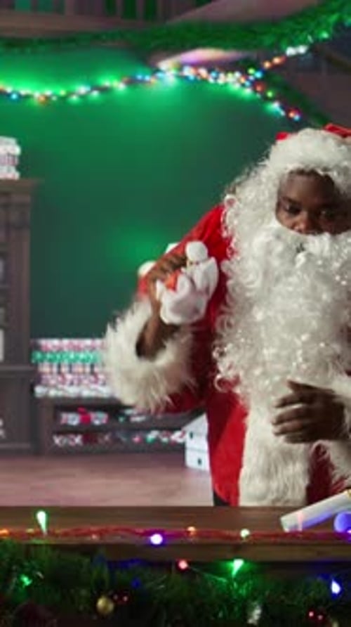 Vertical Video African American Saint Nick Filling Red Sack with Toys and Presents