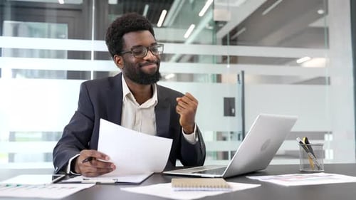 Professional Man Celebrating Success at Office Desk
