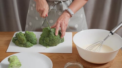 Housewife preparing a healthy meal by chopping broccoli for a vegetarian dish