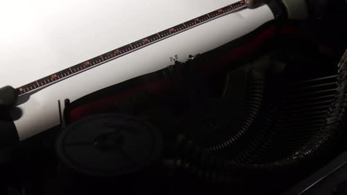 Vintage Typewriter Making a Postscript on a Piece of White Paper Showing the Metal Ruler and Type