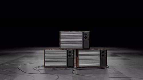 Three retro TVs turn on with the noise of a missing signal. Camera movement towards the screen of a