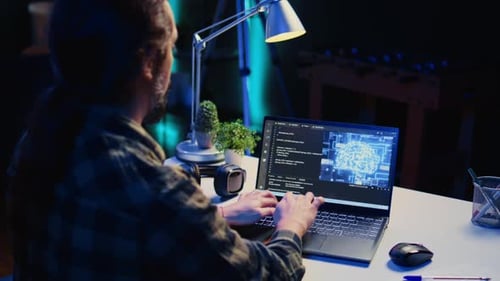 Teleworking IT Specialist in Apartment Office Uses Programming to Upgrade AI