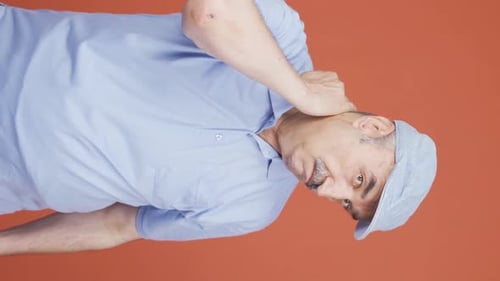 Man Gesturing Energetically on Orange Background Vertical Video