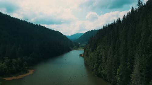 River Flowing Through Mountains with Lush Trees From Above