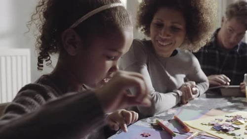 Little Girl Drawing with Mother and Father at Table