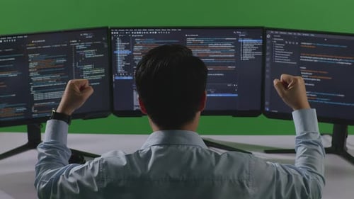 Happy Asian Man Celebrating While Write Code With Multiple Computer Screens In Green Screen