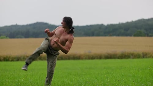 Man Practicing Martial Arts in a Rural Field