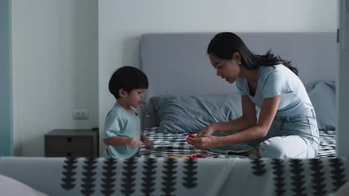 Mother and Child Playing with Toy Blocks on Bed