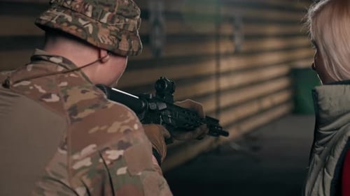 Close Up At a Professional Shooting Range Military Trainer Tells a Girl How to Properly Handle NATO