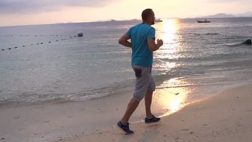 Young Man Jogging on Beach During Sunset Active