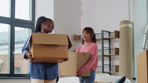 Moving, People and Real Estate Concept - Women Packing Boxes at Home Accommodation