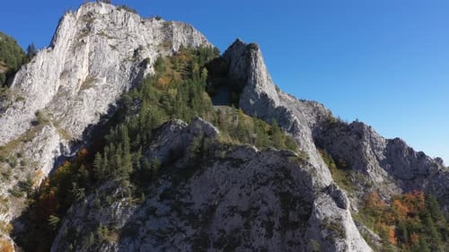 Aerial view of rocky limestone mountains and autumn forest