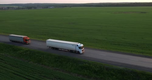 Trucks with a Semitrailer Drive One After Another Along the Highway Aerial