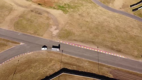 Aerial birds eye view of tow truck pulling racing vintage car to pit stop on Buenos Aires racetrack