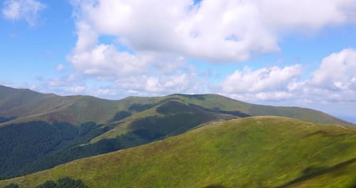 Hilly Green Mountains Under a Bright Blue Sky with Clouds Natural Phenomenon Concept