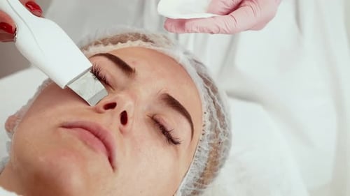 Beautician Using Ultrasound Exfoliation Device During Skincare Session in Aesthetic Center Expert