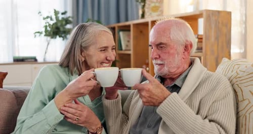 Senior Couple Laughing and Drinking Coffee at Home