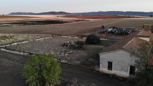 Aerial view of the farm with tractors in Spain. Farmyard at sunset