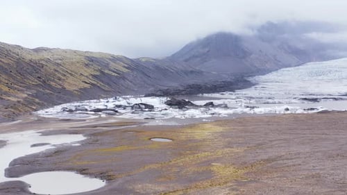 Glacial scenery with icebergs in lagoon at foot of KvĂarjökull glacier, receding by climate change