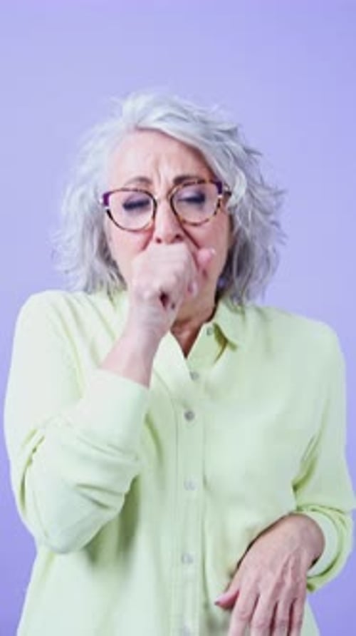 Elderly Woman Coughing and Feeling Unwell in Bright Setting
