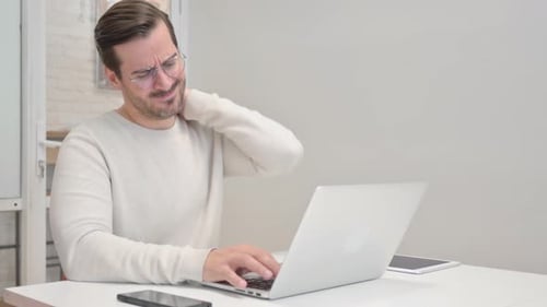 Middle Aged Man having Neck Pain in Office